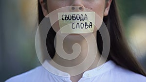 Freedom of speech phrase in russian over female taped mouth, democracy concept