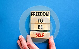 Freedom to be self symbol. Concept words Freedom to be self on wooden blocks on a beautiful blue table blue background.