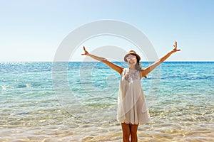 Freedom woman in free happiness bliss on beach. Smiling happy girl in white summer dress in vacation outdoors