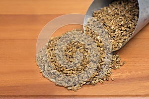 Freekeh in a grain scoops in wood background