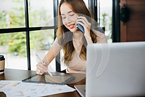 Freelance Asian business woman sitting at cafe call mobile phone talking and