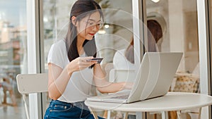 Freelance Asian women online shopping at coffee shop. Young Asia Girl using laptop, credit card buy and purchase e-commerce on