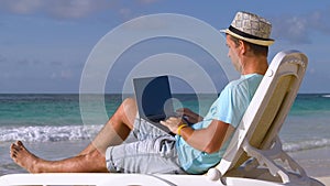 Freelance at beach working under the palm tree.