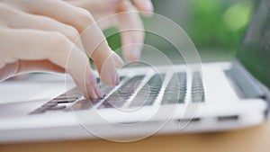 A freelance girl is typing a letter about work on the laptop keyboard. Close-up of a woman's fingers typing on a