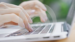 A freelance girl is typing a letter about work on the laptop keyboard. Close-up of a woman& x27;s fingers typing on a