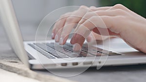 A freelance girl is typing a letter about work on the laptop keyboard. Close-up of a woman& x27;s fingers typing on a