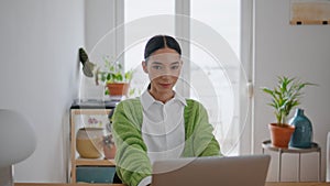 Freelance girl using laptop posing at room portrait. Smiling woman sitting table