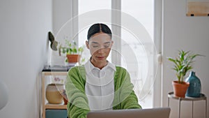 Freelance girl using laptop posing at room portrait. Smiling woman sitting table