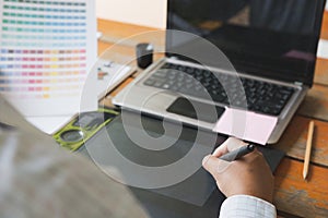 freelance graphic designer using digital tablet, computer, man w