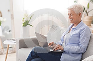 Freelance Jobs For Seniors. Smiling Elderly Lady Working On Laptop At Home