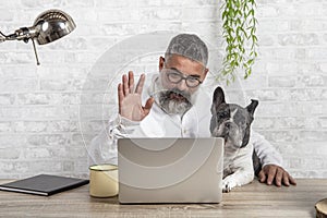 Freelance man working from home with his dog. Entering a meeting with a cute dog