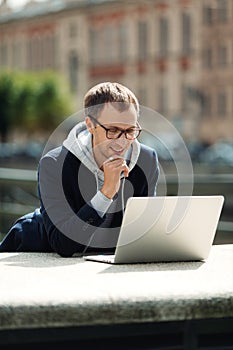 Freelance programmer or web designer read email on laptop computer walking city using 5g internet