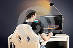 freelance video editor sit on white chair and desk in his office and cut some video footage with graphic tablet