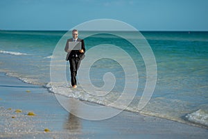 Freelance work, online business. Summer business. Businessman in suit hold laptop and run on sea. Funny business man in