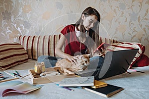 Freelance young woman working in home office with laptop computer and cat. Remote online working, Flexible workspace and