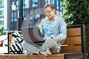 Freelancer enjoying time outside while working remotely on laptop