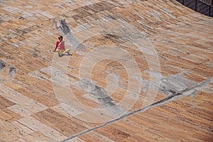 Freelancer girl sitting on stone surface. Marble floor with people near concert hall Casa da musica in Porto, Portugal