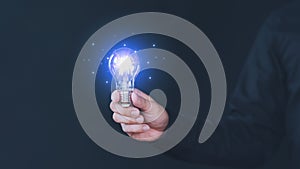 Freelancer hand holding illuminated light bulb. Creative idea, new business plan, motivation, innovation, inspiration.