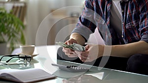 Freelancer holding cash, calculating his salary for project, benefit for work