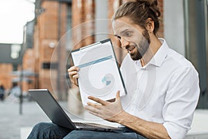 Freelancer man presenting financial report to colleagues through video call on laptop.