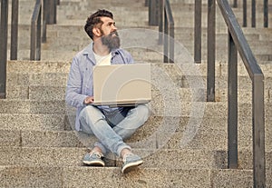 freelancer man sitting with laptop. freelancer man has online laptop communication outdoor.