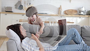 Freelancer mom work from home with little noisy kid: disobedient son distract mother busy texting