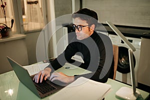 Freelancer at Night Man Working on Notebook Computer in Indoor Setting