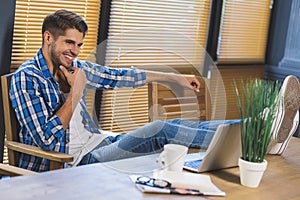 Freelancer relaxing at the office with his feet on table