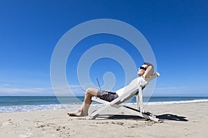 Freelancer resting on sunny tropical beach with sunglasses