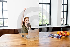 Freelancer showing yeah gesture near laptop