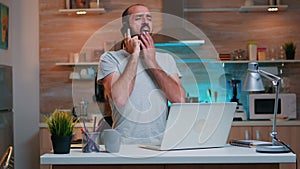 Freelancer talking on phone and yawning