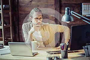 Freelancer thoughtfully looking in computer.