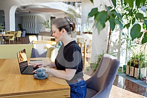 Freelancer Using Laptop in Bright Modern Cafe