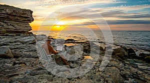 Persona de libre dedicación sobre el computadora portátil sobre el Costa el mar sobre el atardecer 