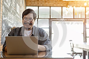 Freelancer is working on his laptop at cafe. A man is typing keyboard on laptop.