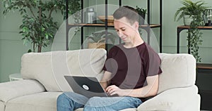 Freelancer Working with Laptop on Sofa in the Living Room