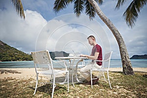 Freelancer working on laptop from tropical destination