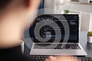 Freelancer writing code on laptop using keyboard.