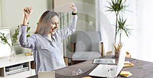 Freelancer young woman celebrating success at home