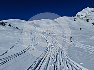 Freerider climbing a mountain, sea of clouds in the background