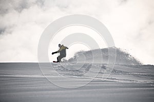 Freerider in full equipment sliding on a snowboard in mountains