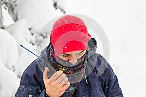 Freerider man talking on a portable radio set in a snowy forest