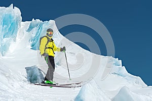 A freerider skier in complete outfit stands on a glacier in the North Caucasus