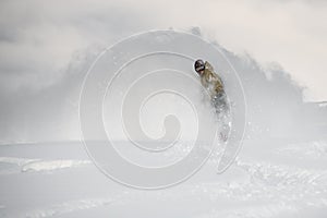 Freerider slides on a snowboard through snow cloud