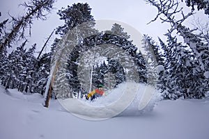 Freerider snowboarder jumping at night with a springboard in the forest