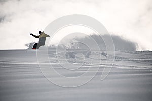 Freerider in sportswear sliding on a snowboard in mountains
