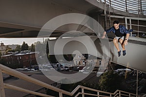 Freerun athlete doing scary jump from high bridge