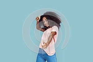 Freestyle. African girl standing isolated on gray posing thumbs up smiling cool