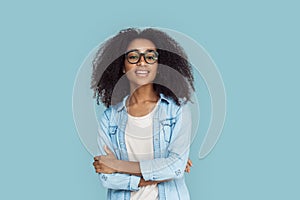 Freestyle. African girl wearing glasses standing isolated on gray crossed arms smiling sassy close-up