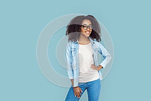 Freestyle. African girl wearing glasses standing isolated on gray hand on hips posing smiling joyful